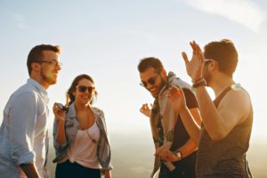 Die Sonne scheint, es ist Frühling und eine Frauen und drei Männer zwischen 25 und 40 Jahren, lächeln und sprechen über ihre Erfahrungen. Sie stehen auf einem Hügel und haben eine gute Zeit.